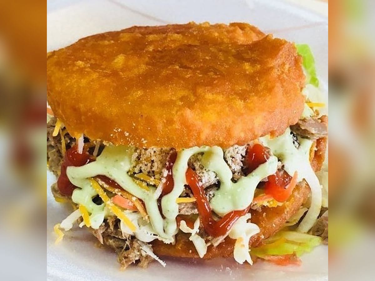 Arepa tumbarrancho rebozada y frita, abierta y rellena de queso y mortadela