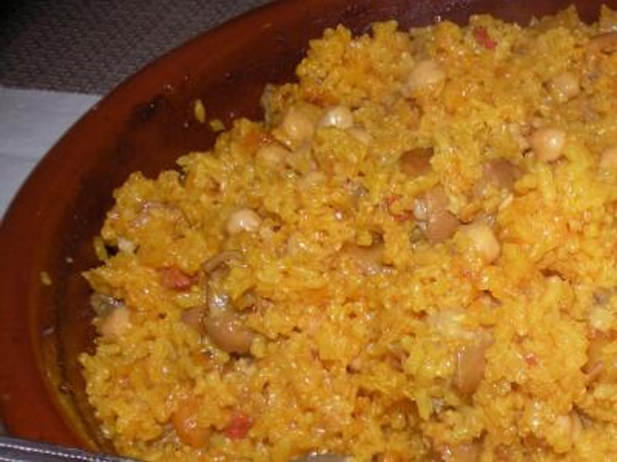 Arroz blandito con paticas de cochino y garbanzo servido en un plato hondo