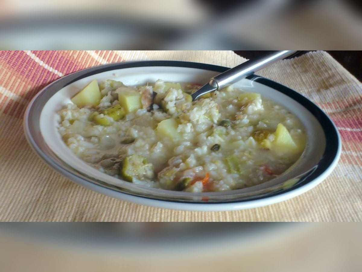 Asopao de jurel salpreso servido en un plato hondo, con arroz, papa y vegetales
