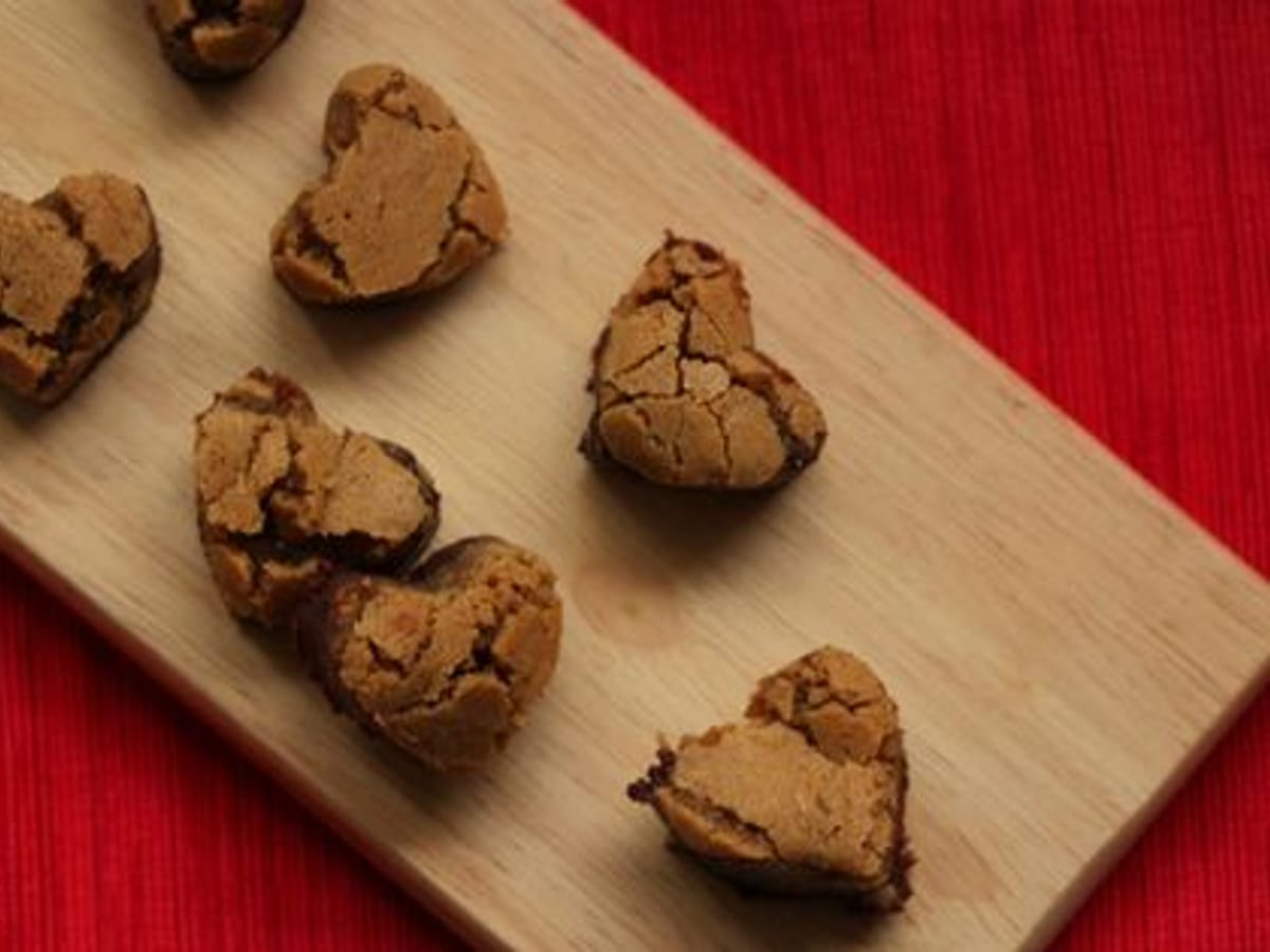 Brownies de chocolate blanco cortados en forma de corazón sobre una tabla de madera