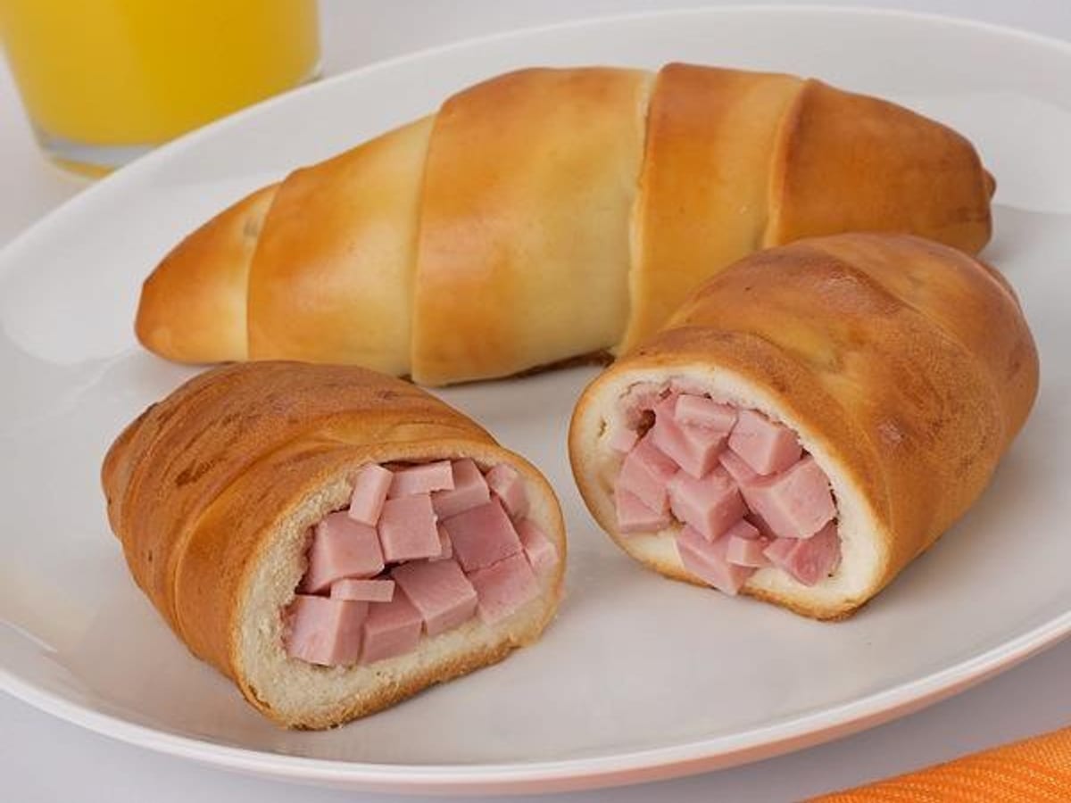Cachitos de jamón horneados y dorados sobre una bandeja
