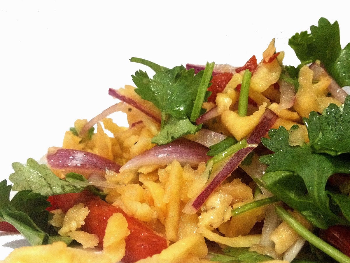 Ensalada de plátano verde rallado y sofrito, mezclada con tomate, cebolla y lechuga