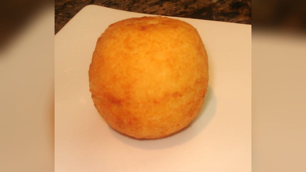 Papita de yuca rellena de queso, frita y dorada, sobre un plato