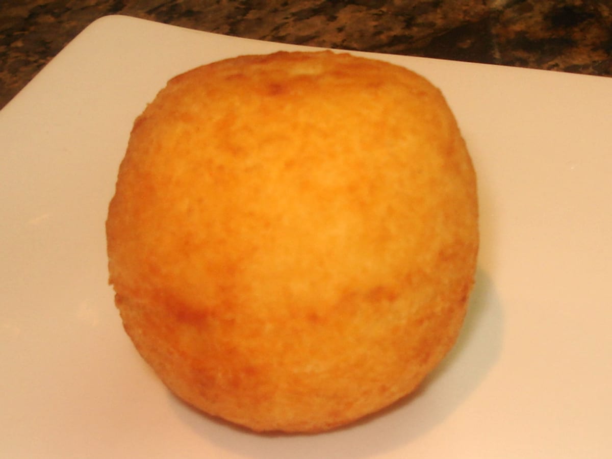 Papita de yuca rellena de queso, frita y dorada, sobre un plato