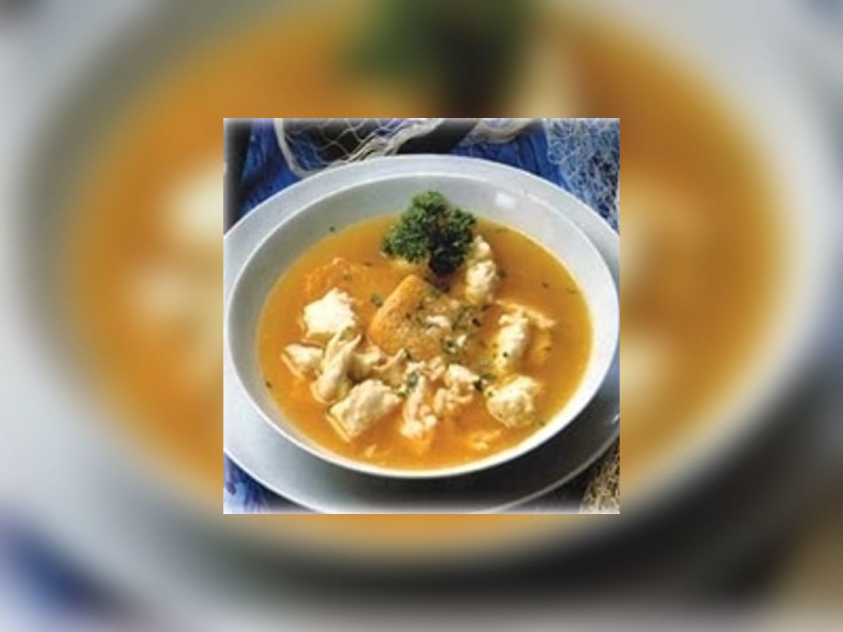 Sancocho de sapoara servido en una cazuela de barro con casabe