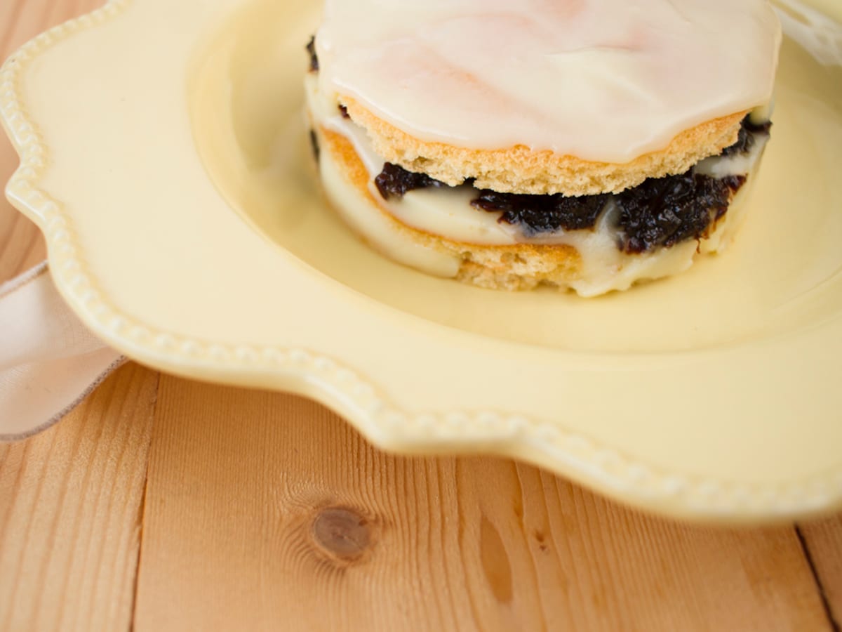 Torta real en capas de bizcochuelo, natilla y dulce de ciruelas pasas servida en un envase